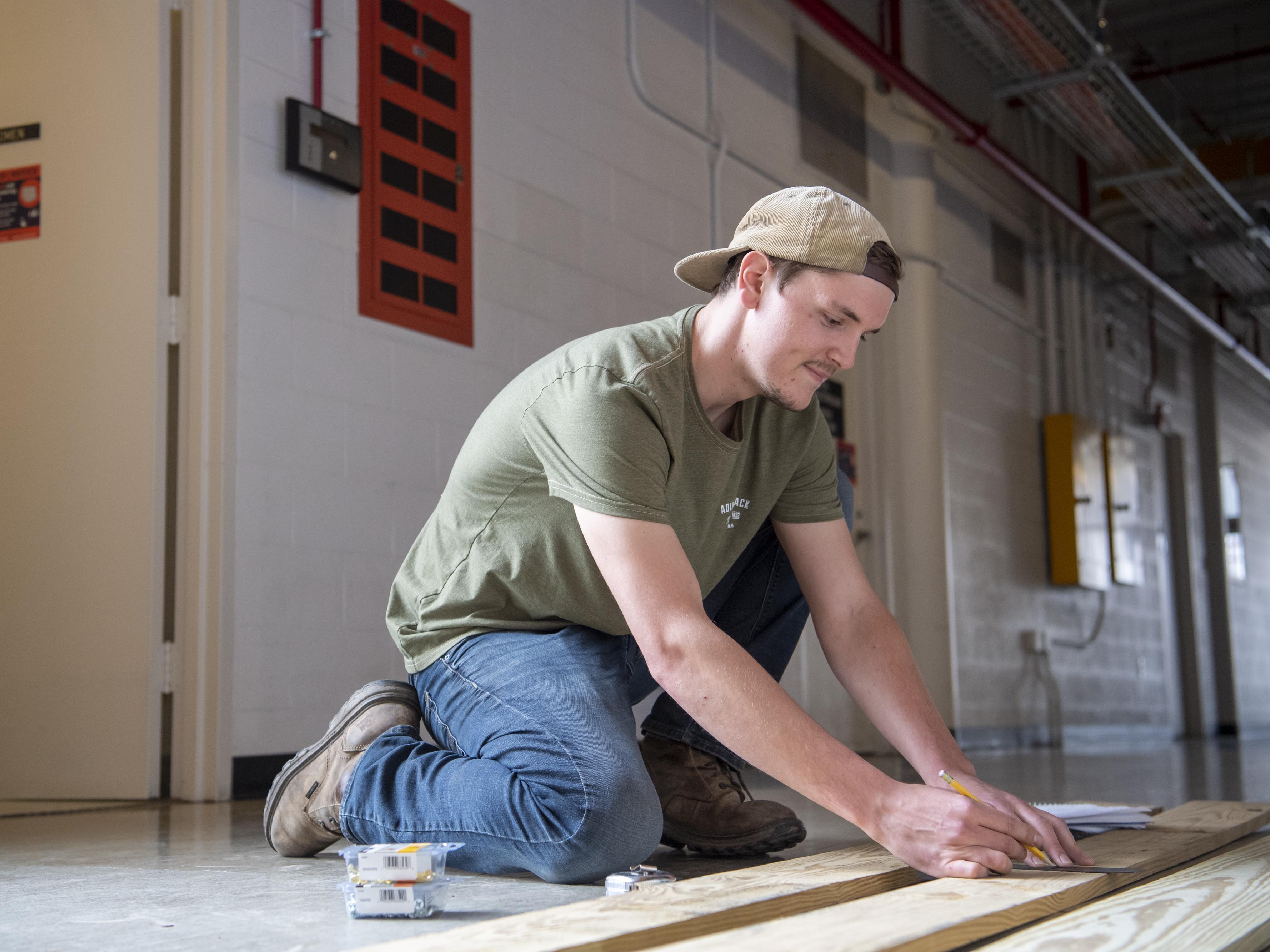 Man measuring a 2 by 4.