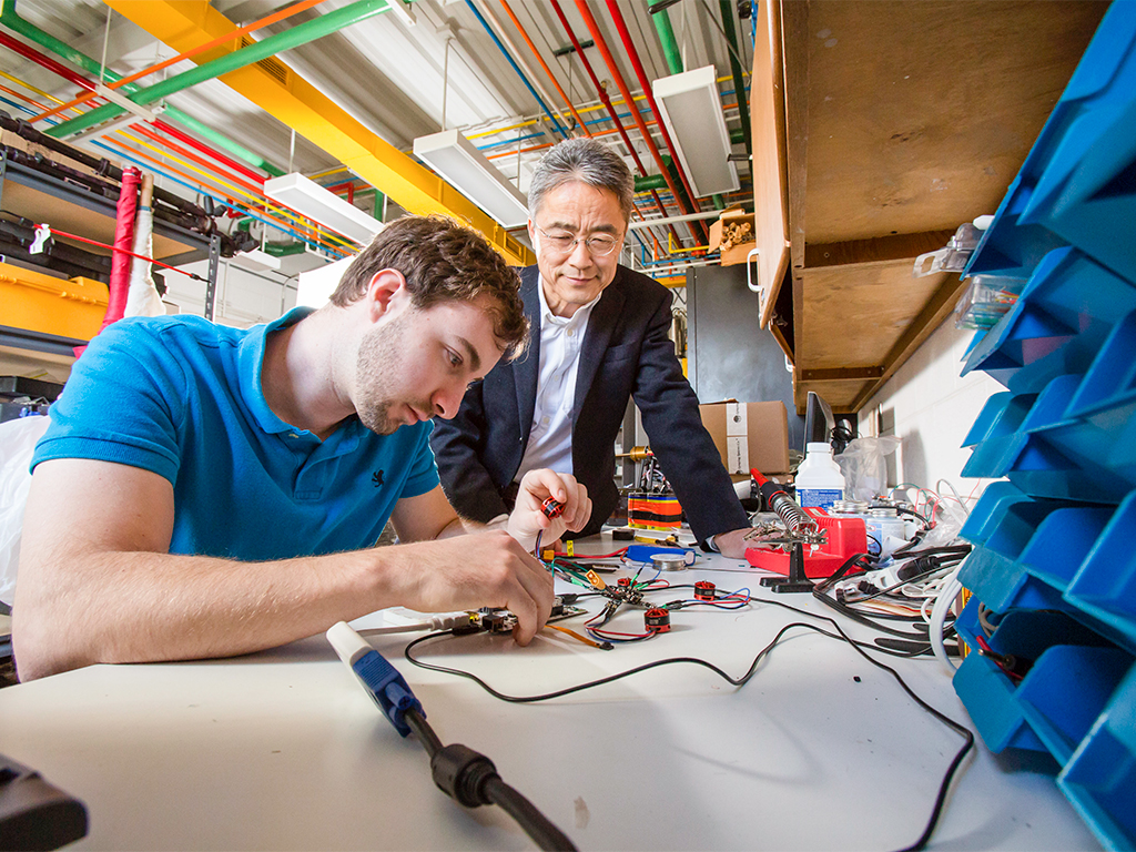 Student and professor work on programming a device.
