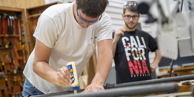 Student using wood glue on project