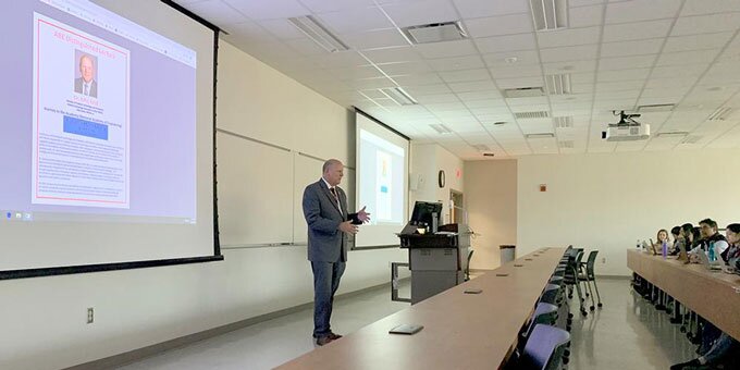 Instructor lecturing an audience.