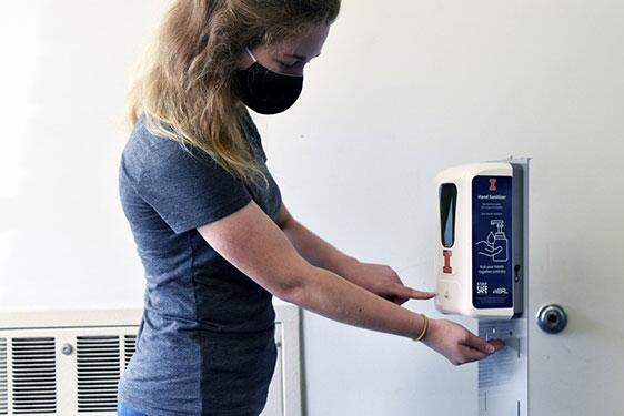 Student using hand sanitizer.