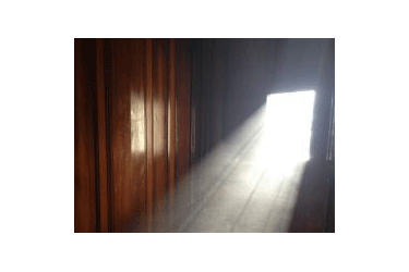 Sun rays highlighting dust in a barn.